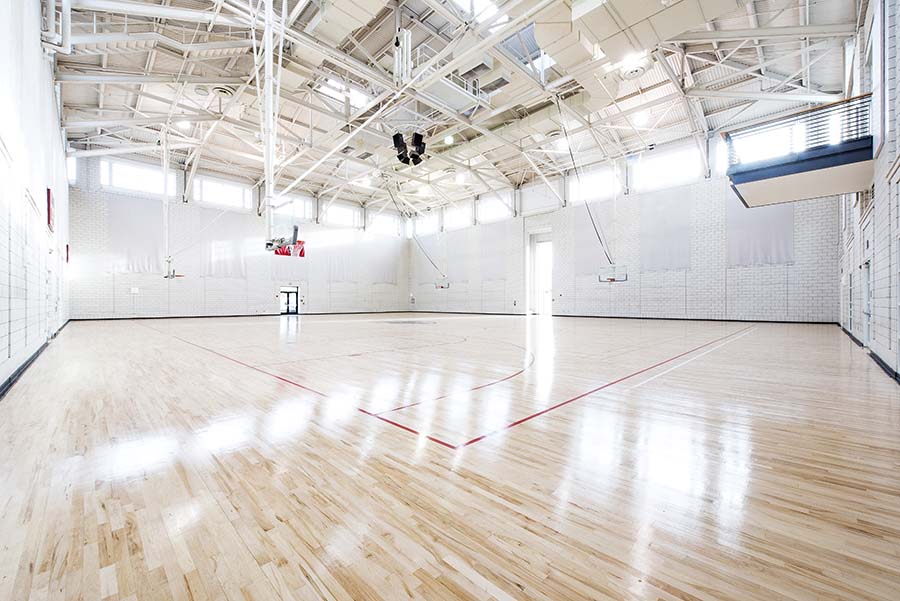 Photo of Wiegand Gym from corner featuring basketball hoops and speakers